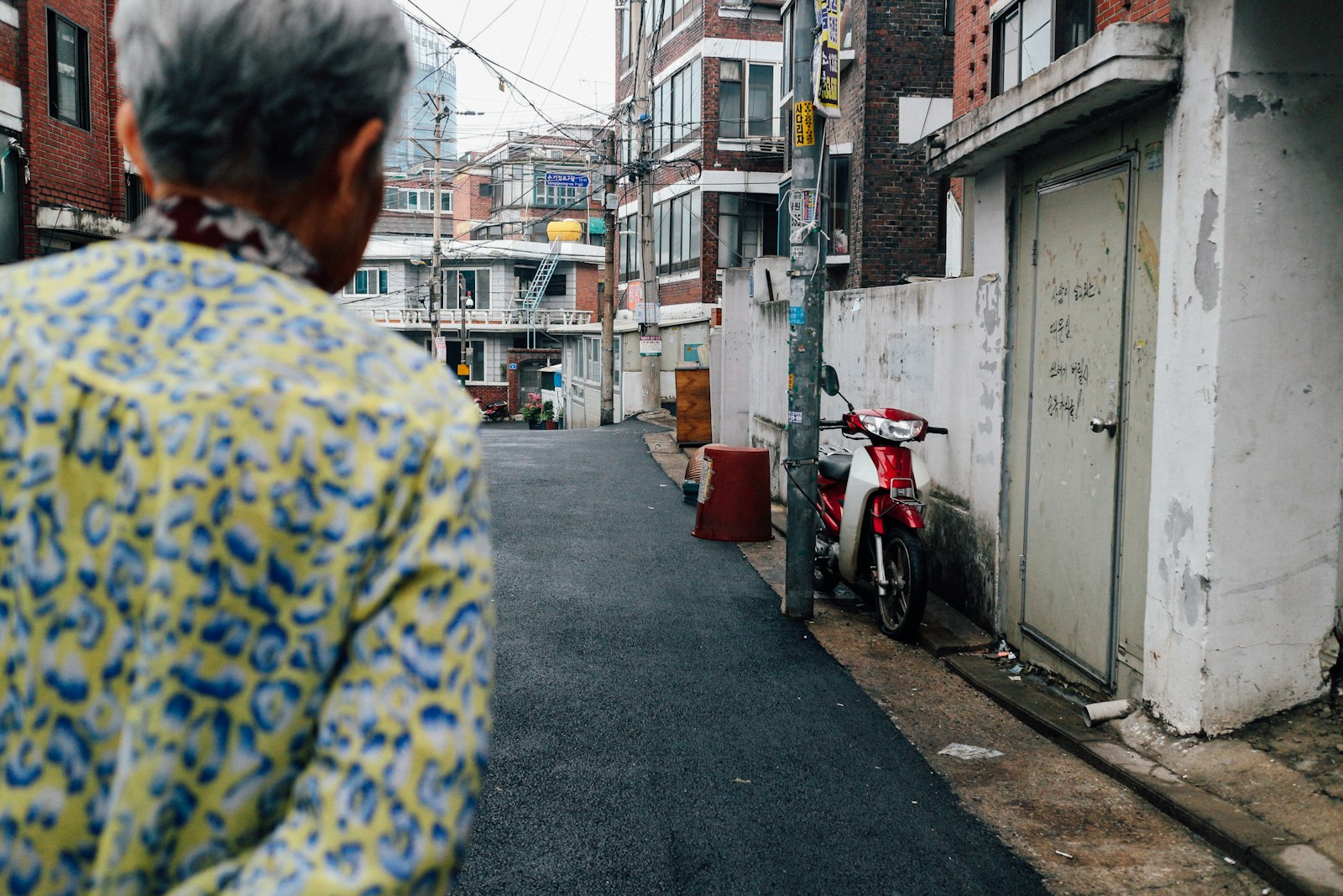 Canon EF-M 22mm F2 STM sample photo. Person walking on grey photography