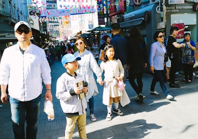 A lively street scene with travelers enjoying a guided city walking tour under colorful banners.