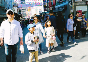 Colorful city street filled with smiling tourists exploring local culture.