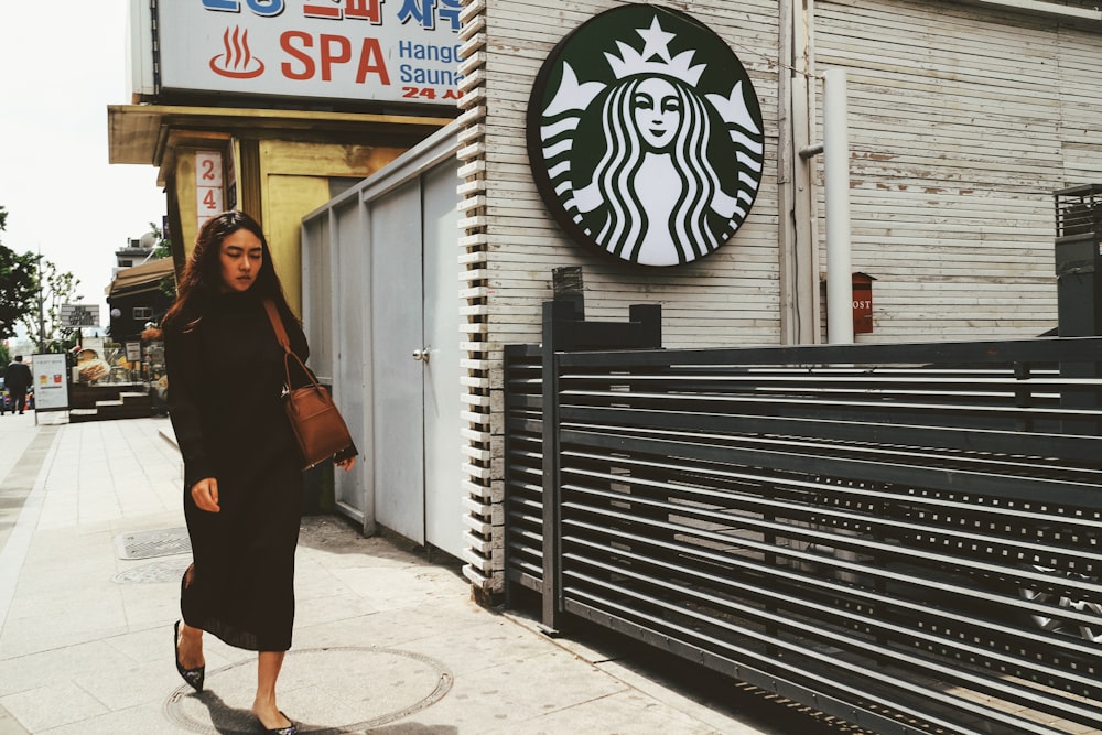 woman walking on sidewalk during daytime