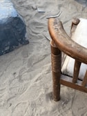 Close-up of a thickened frame supporting a camping chair on rocky ground.