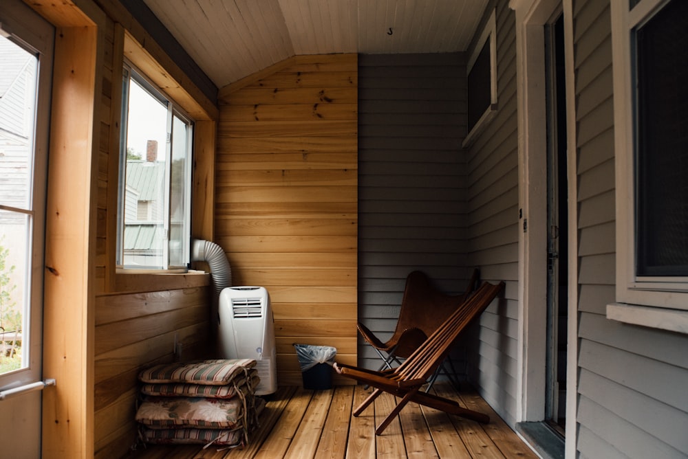 brown wooden chair near clear glass window