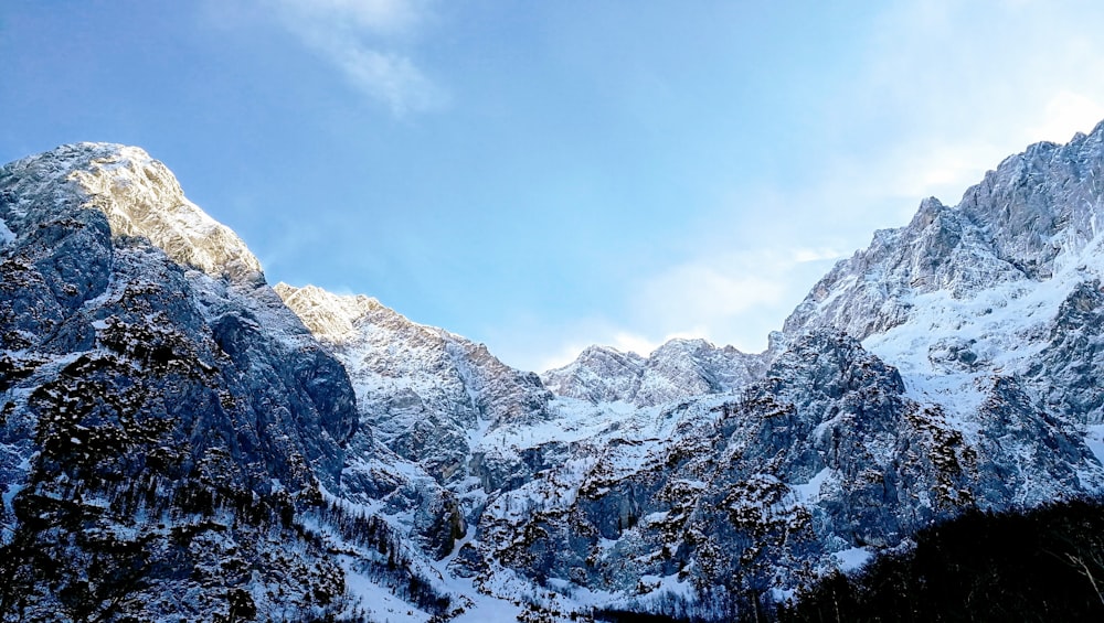 Tagsüber schneebedecktes Gebirge unter weißen Wolken