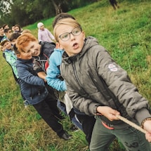 group of children pulling brown rope