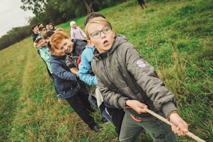 group of children pulling brown rope