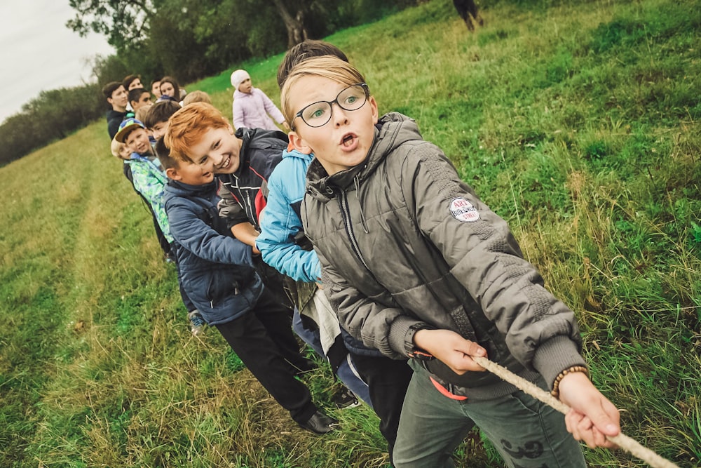 group of children pulling brown rope