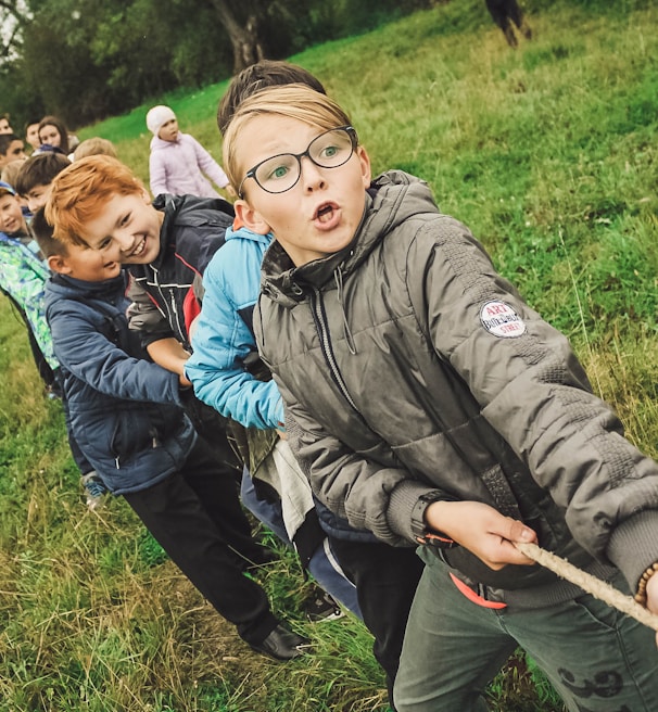 group of children pulling brown rope