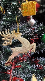 A festive card featuring a gold embossed reindeer with a textured finish.