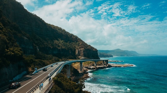 photography of black concrete road near body of water in Sea Cliff Bridge Australia