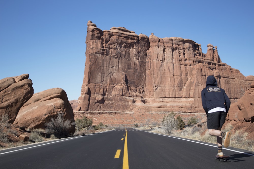 person in blue hoodie skateboarding near ruins