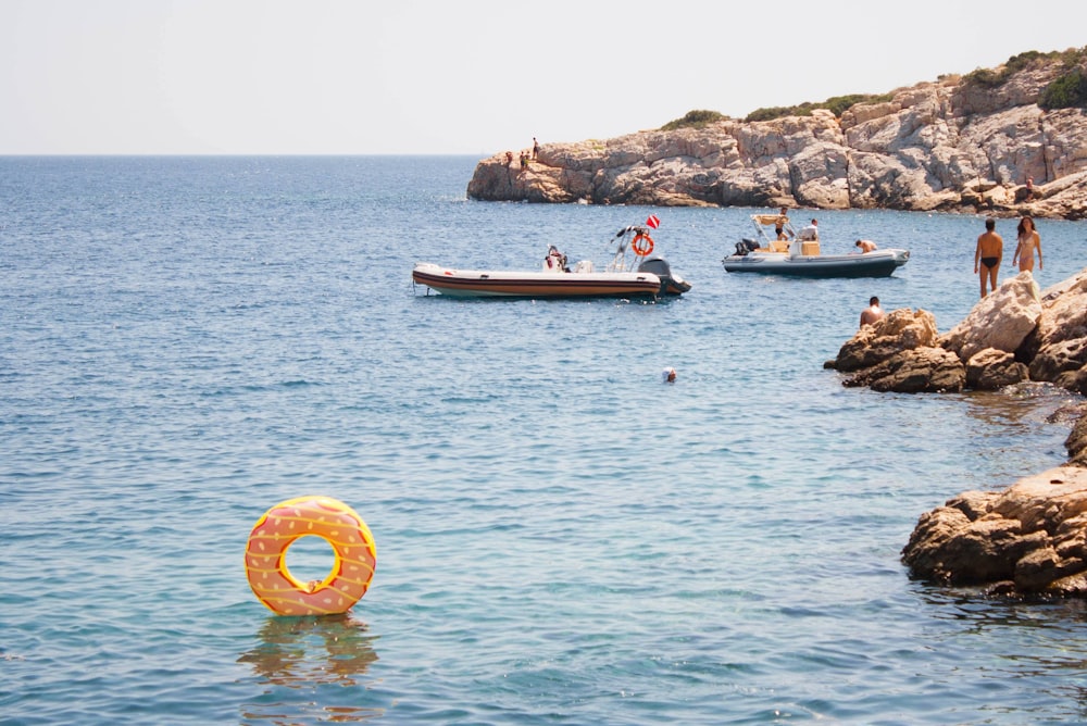 group of people swimming on body of water during daytime