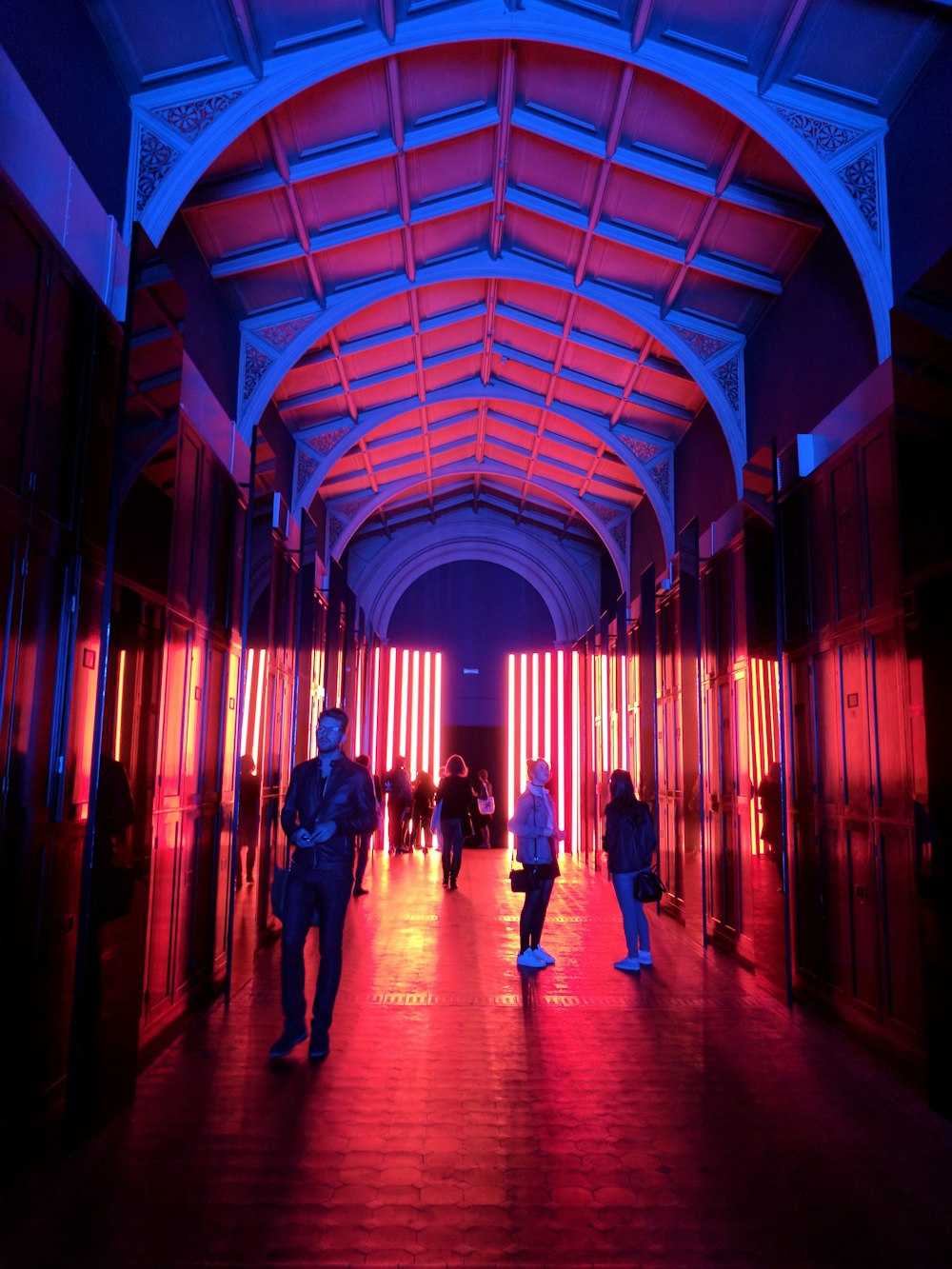 people walking on alley with white roof during nighttime