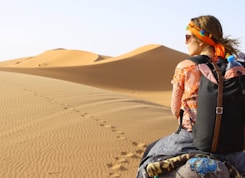 woman riding animal on dessert