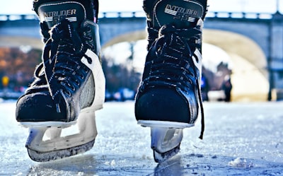 close-up photo of black-and-gray intruder ice skates on frozen body of water ice skates google meet background