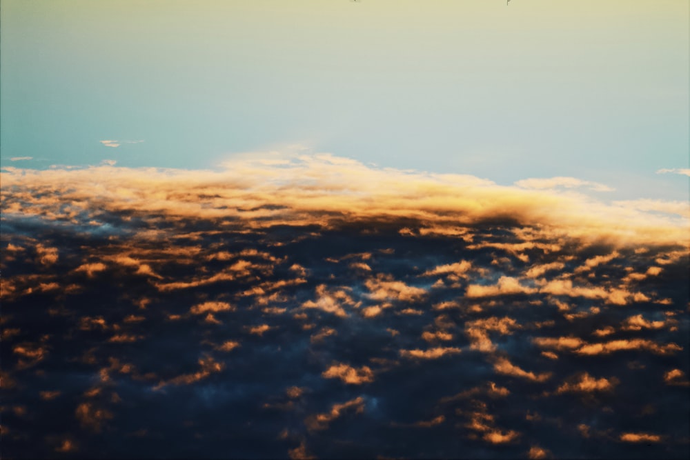 a plane flying high above the clouds in the sky