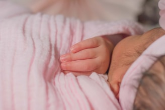 A peaceful image of a sleeping baby wrapped in a soft blanket.