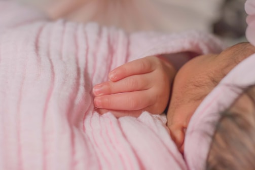 A close-up of a soft, pastel-colored baby blanket folded neatly on a crib.