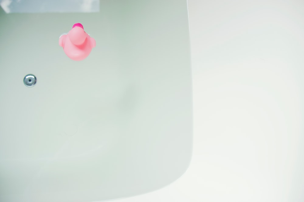 pink rubber duck on bathtub