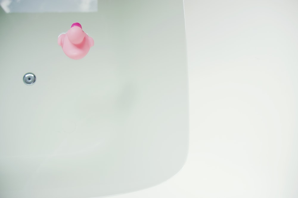 pink rubber duck on bathtub