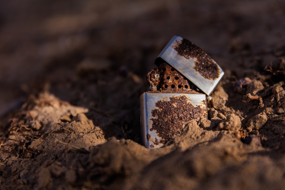 brown and black flip lighter on brown soil