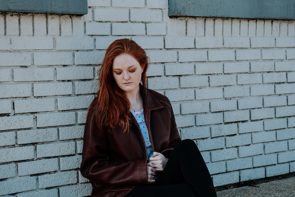 woman sitting near wall