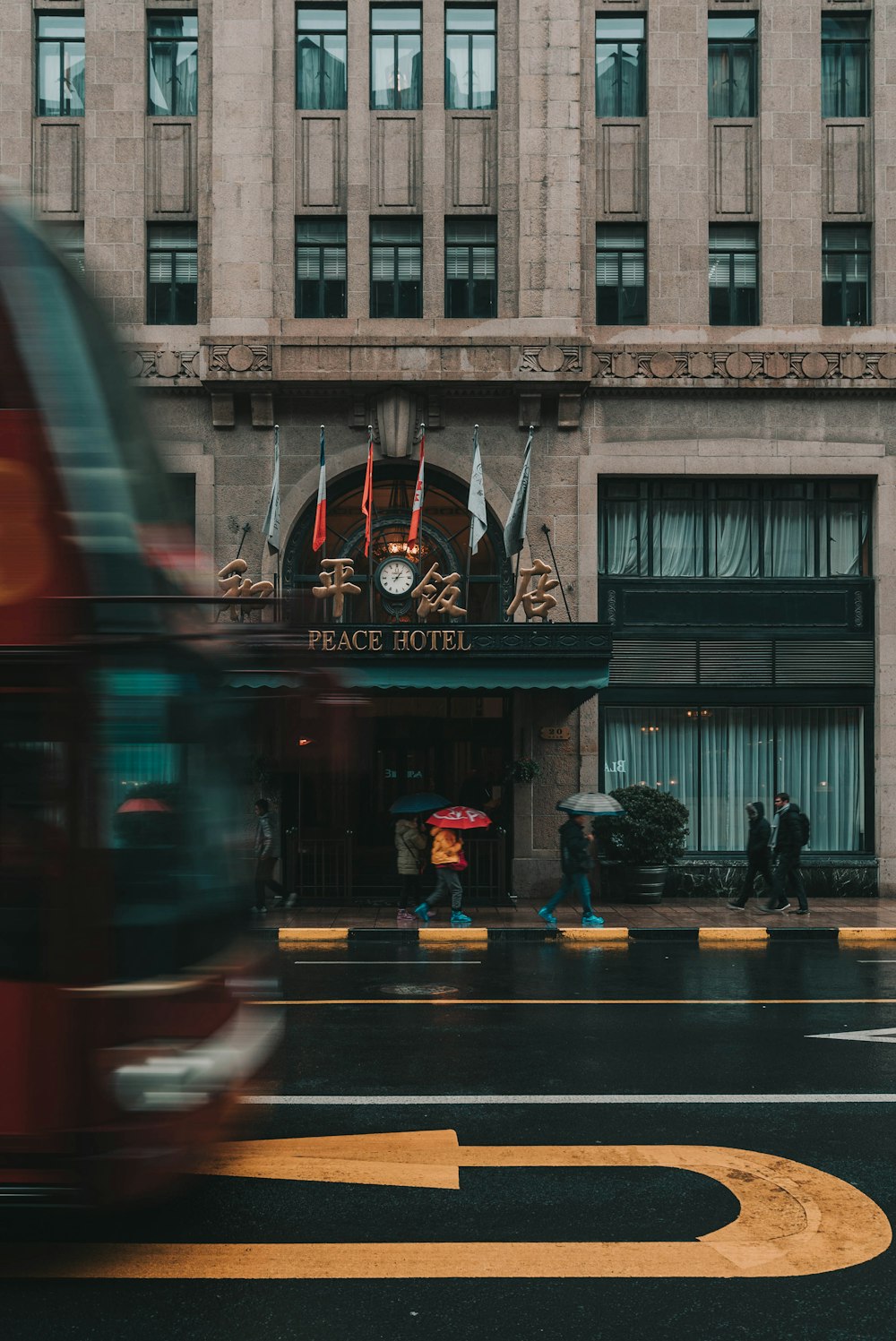 people walking on pathway beside Peace Hotel