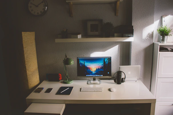 A serene desk setup featuring headphones and a smartphone playing an abundrawealth manifestation audiobook, with subtle natural light.