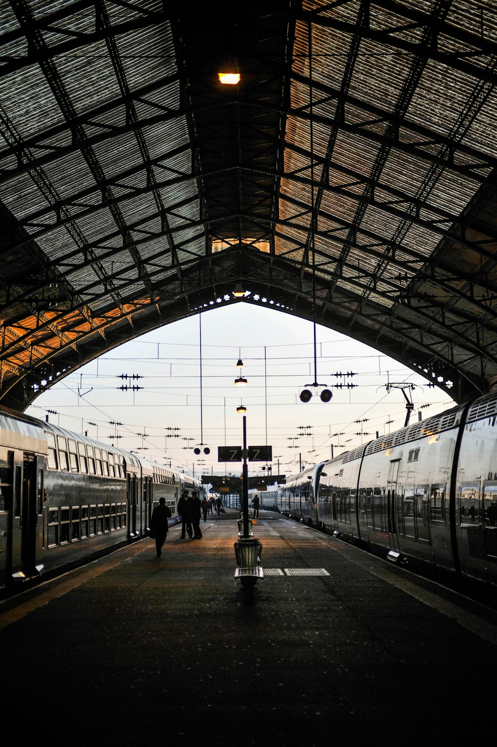 Pessoas caminhando ao lado do trem cinza