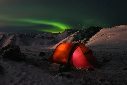 The team setting up camp on the frozen Antarctic plateau at dusk with colorful tents.