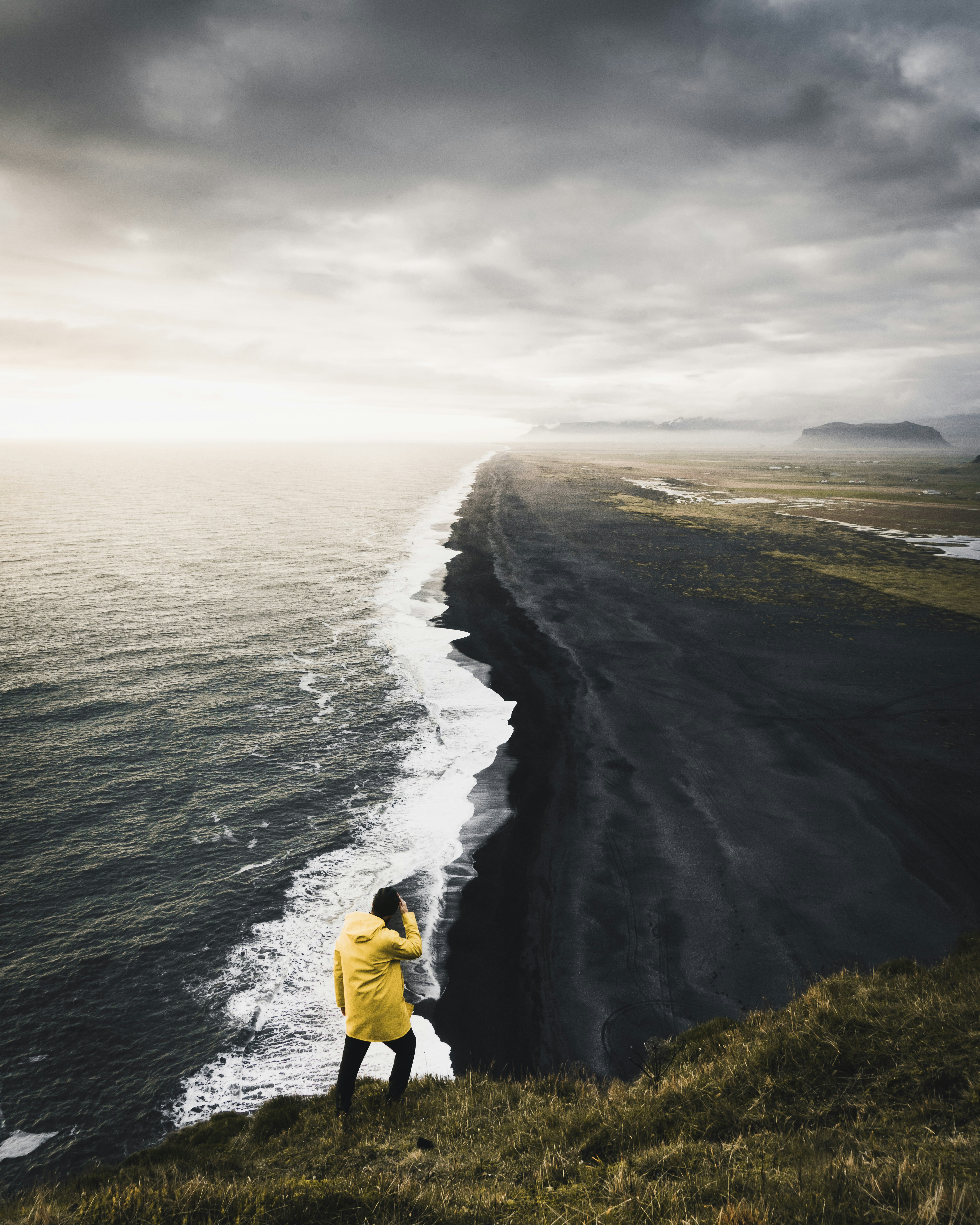 great photo recipe,how to photograph my favourite view in iceland.  the never ending volcanic black beach is absolutely breathtaking in person.; man on top hill near body of water