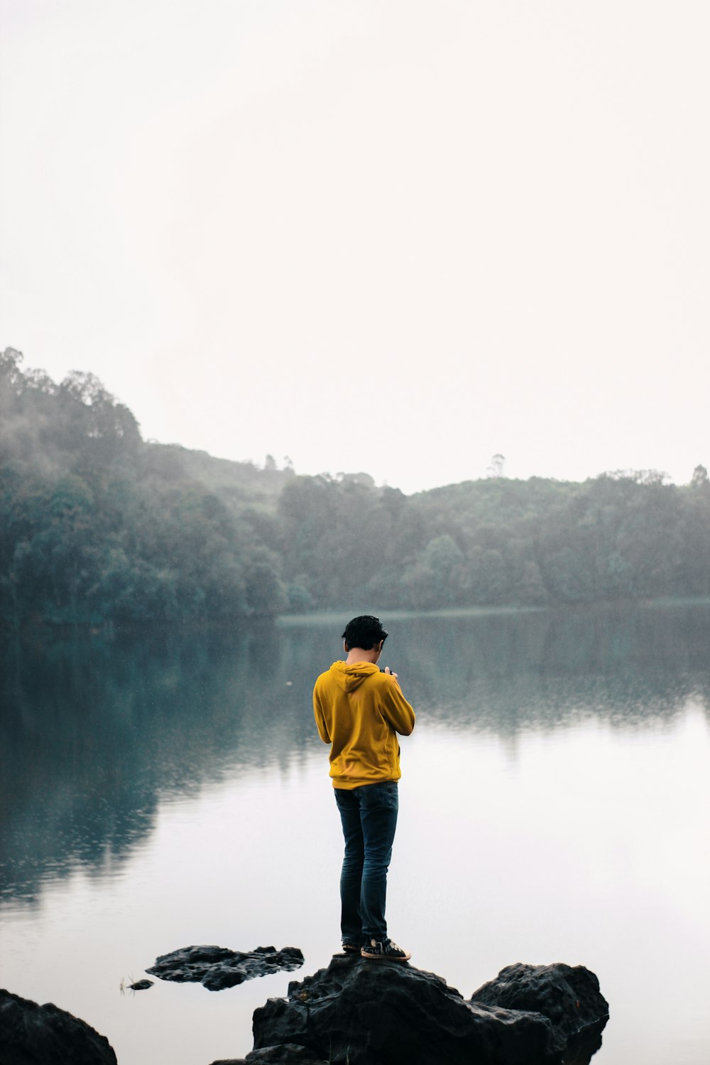 a person standing on a rock near a body of water