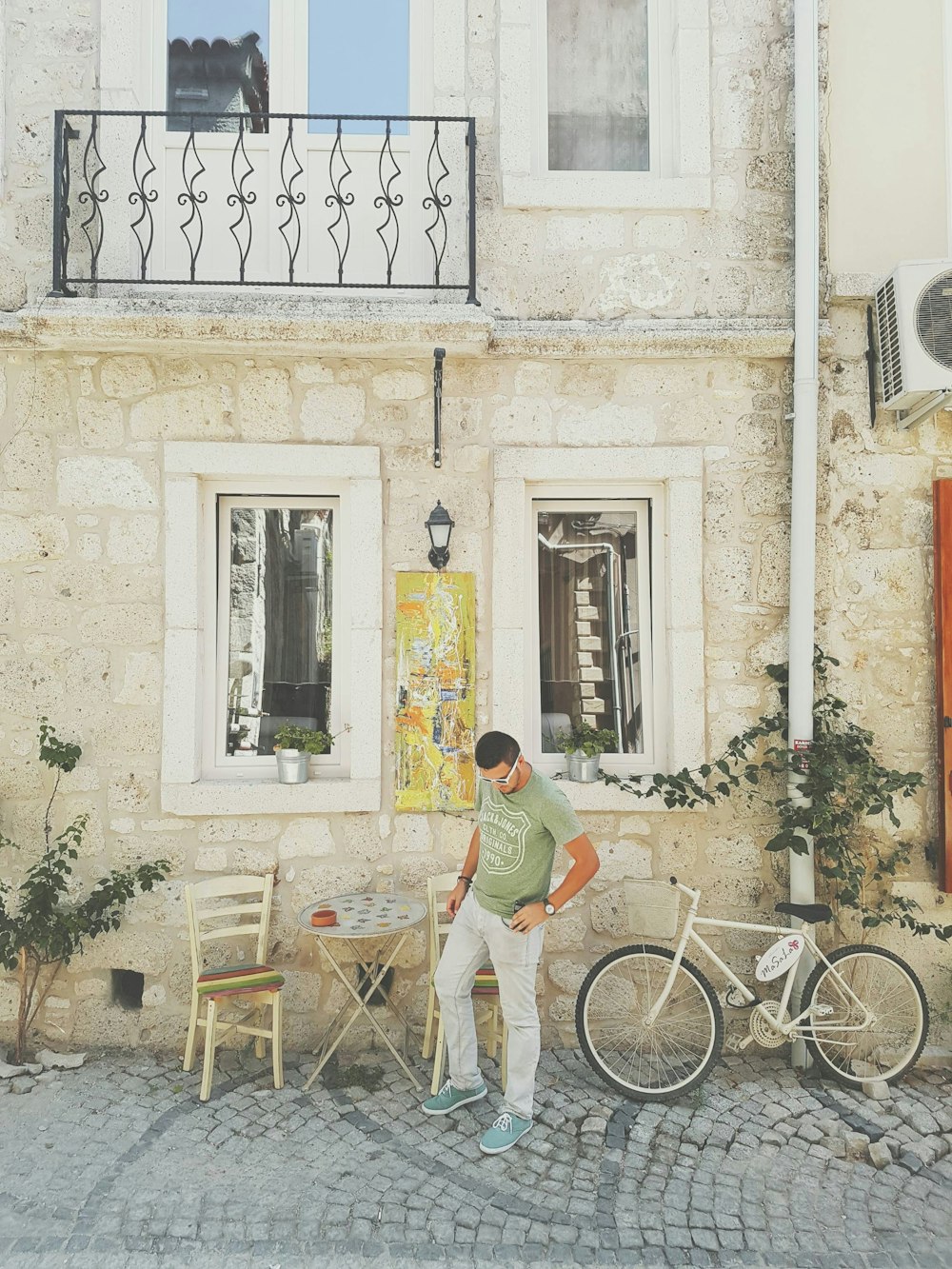 a man standing in front of a building next to a bicycle