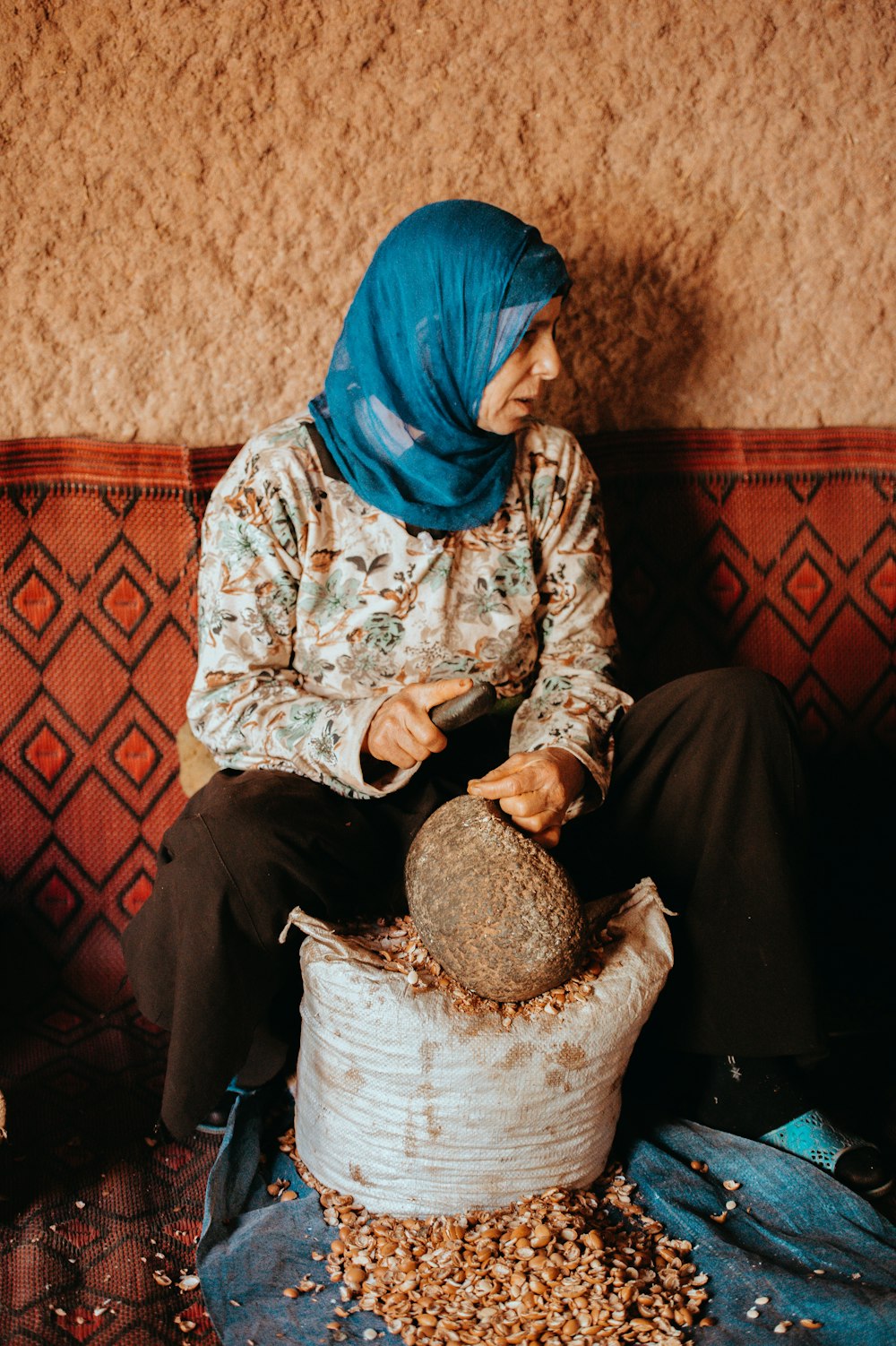 woman sitting beside grey rock