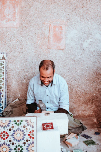 man smiling sitting on floor during daytime