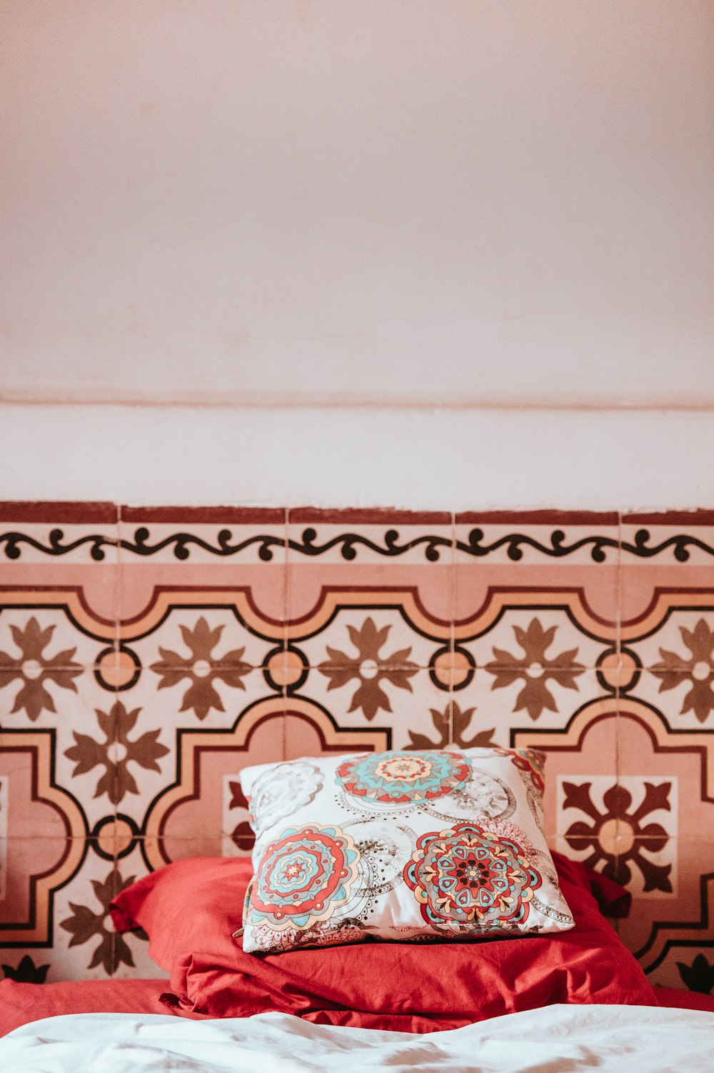 Almohada de damasco multicolor sobre tela rosa