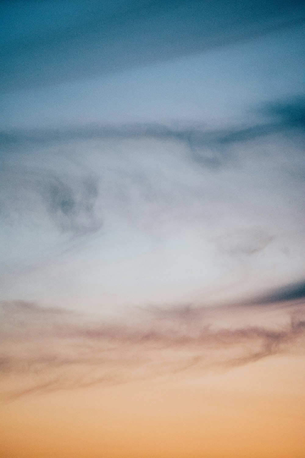 a plane flying in the sky at sunset