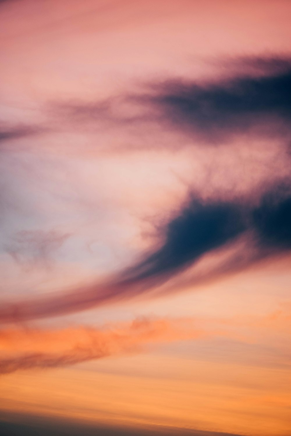 a plane flying in the sky at sunset