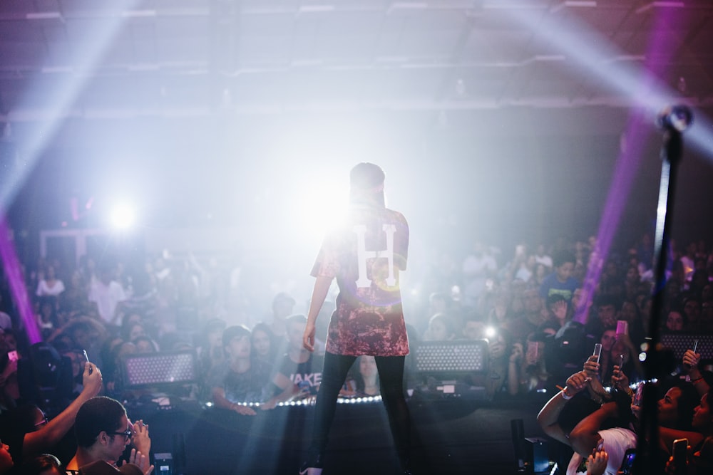 man singing on stage in front of crowd