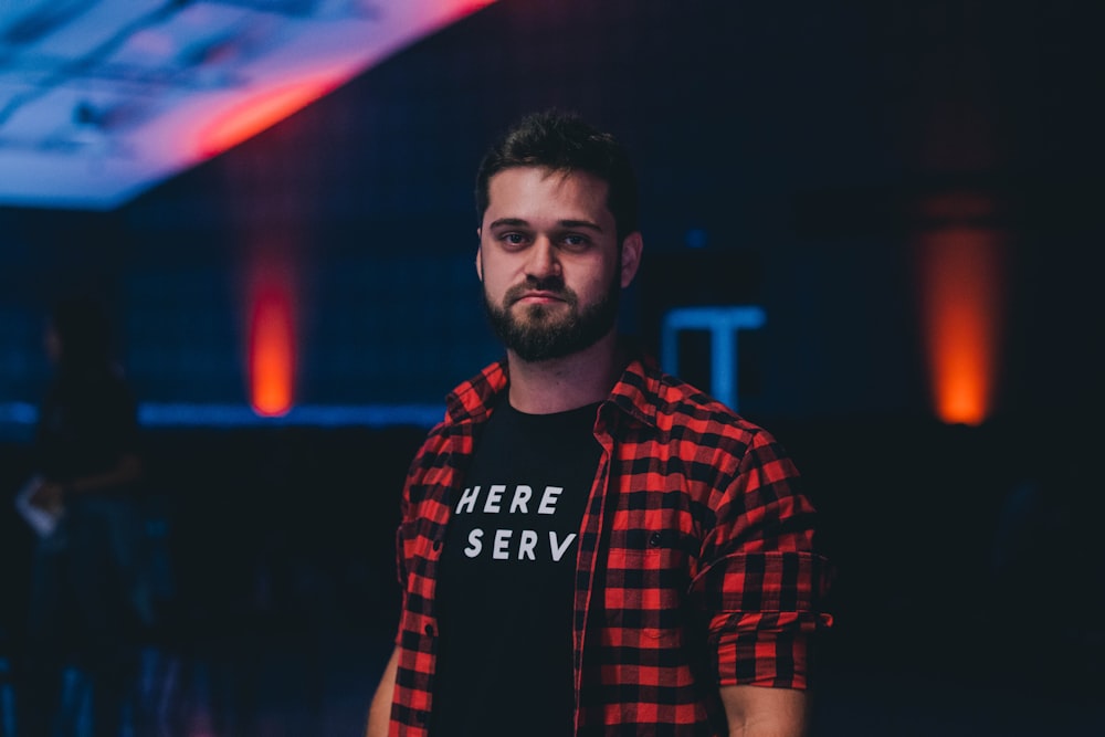 depth of field photography of man wearing black and red plaid button-up T-shirt and black shirt