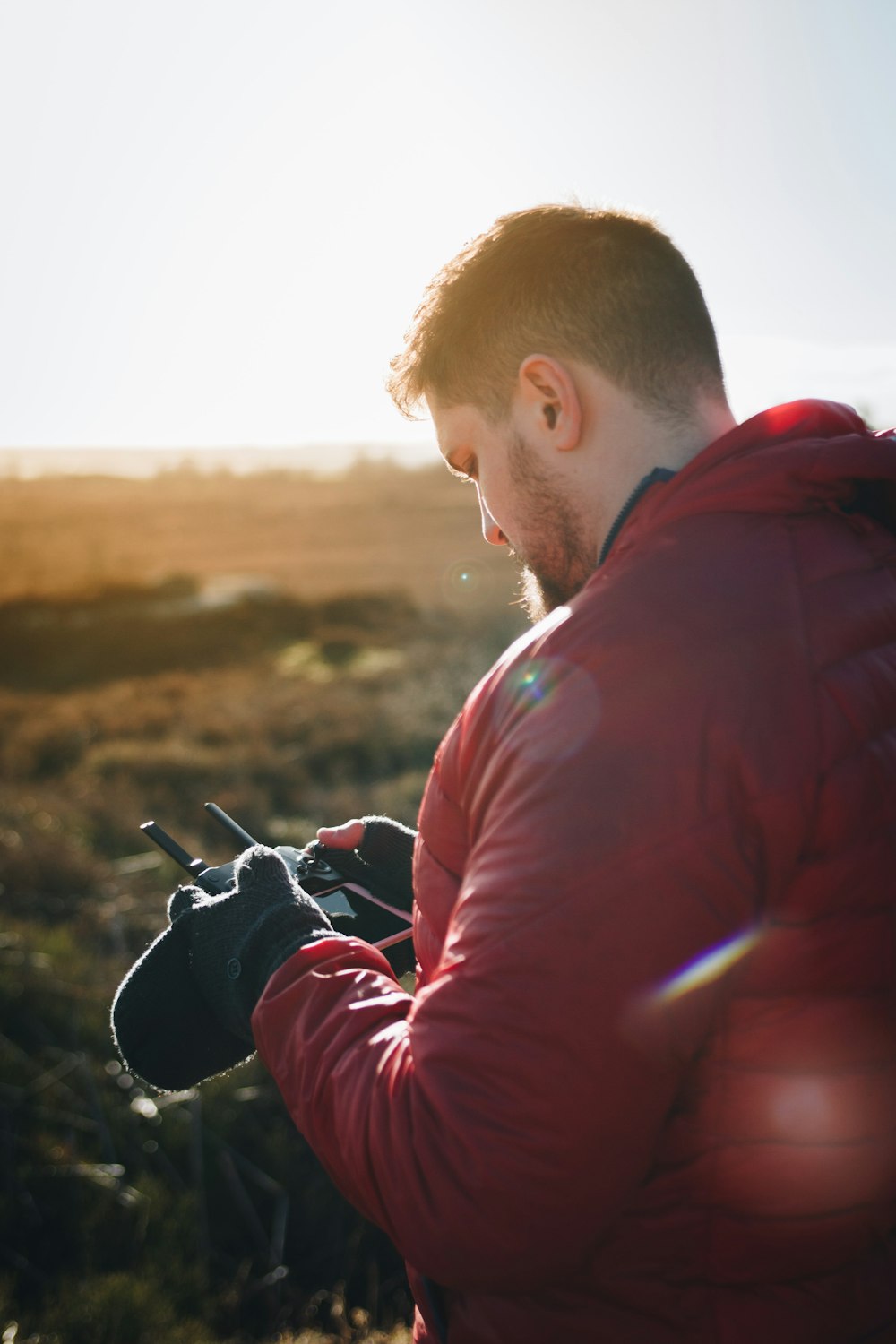 Mann in roter Daunenjacke mit Fernbedienung