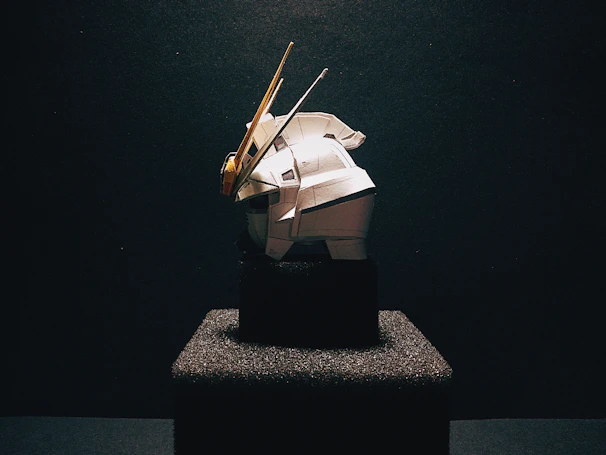 An advanced robotic prototype displayed on a minimalist pedestal with subtle blue lighting highlighting its contours.