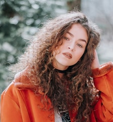 shallow focus photography of woman holding her hair while taking selfie