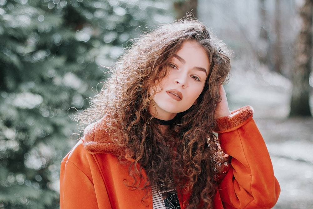 shallow focus photography of woman holding her hair while taking selfie