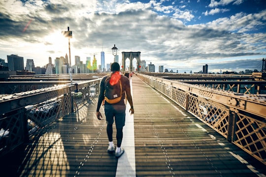 man walking on bridge in Brooklyn Bridge United States