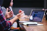 person gesturing during meeting with laptop