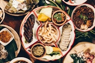 A colorful assortment of traditional dishes from local restaurants arranged on a wooden table.