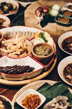 A colorful spread of party platters including spring rolls, banh mi trays, and Thai curries on a festive table.