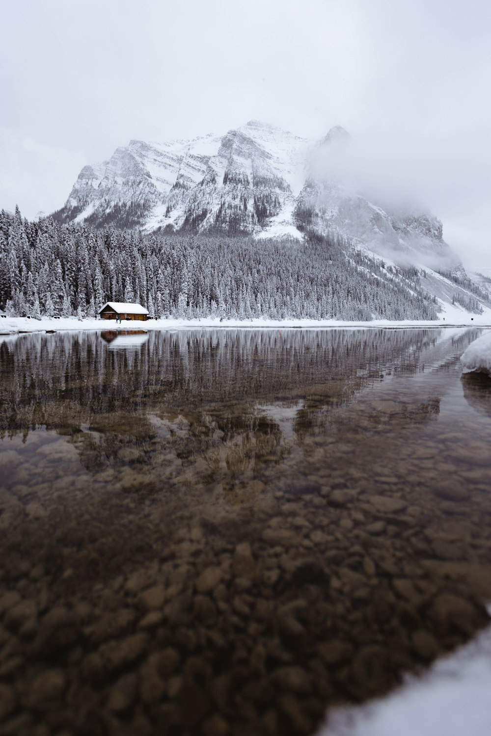 mountain covered with snow near body of water