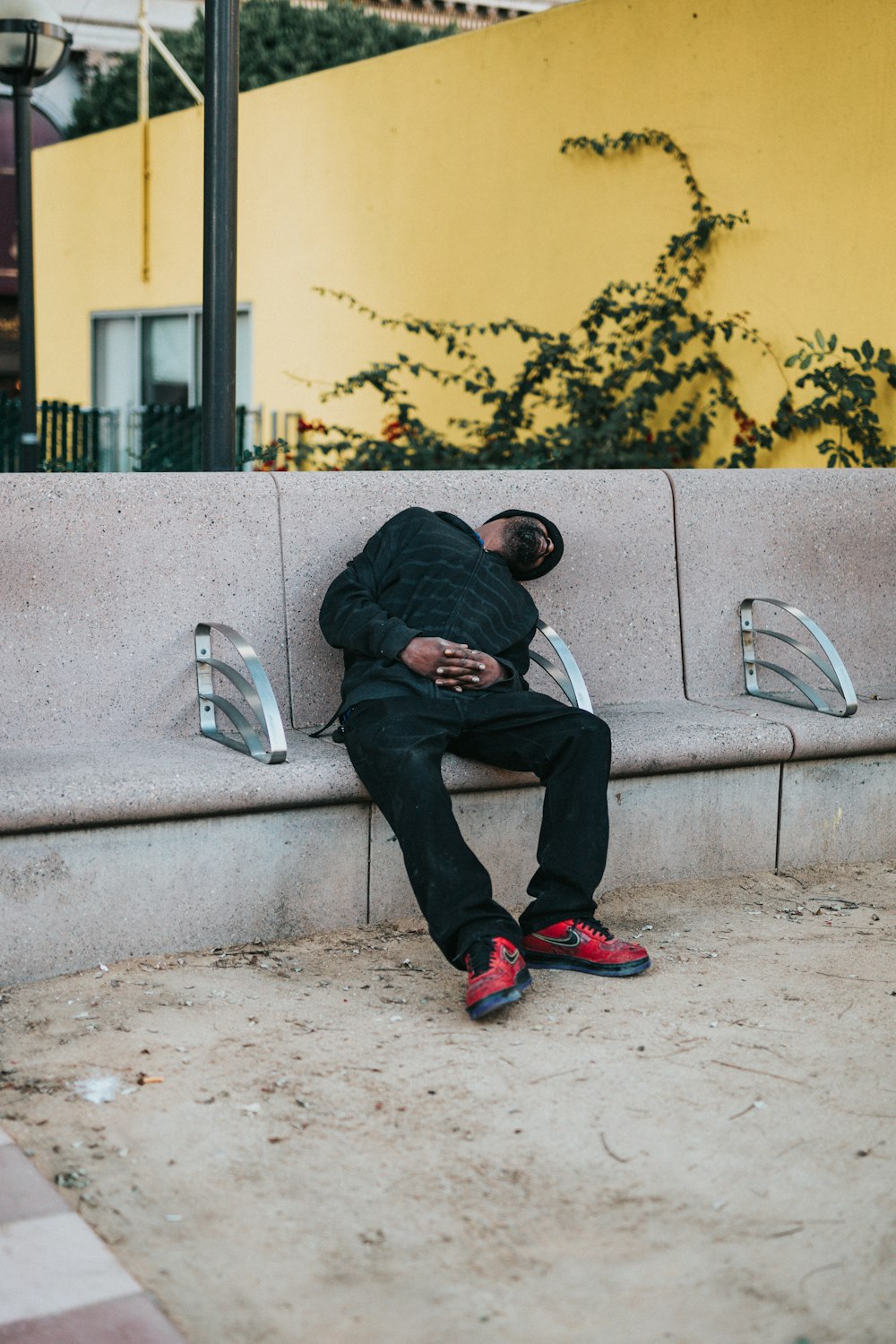 hombre durmiendo en un banco de hormigón beige en la foto de enfoque