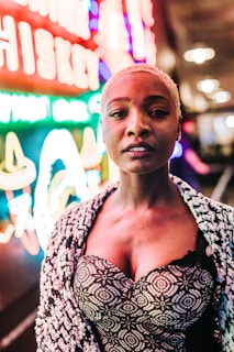 A vibrant model wearing a bold, patterned jacket from Nevaro Apparel's latest collection, standing confidently against a colorful urban backdrop.